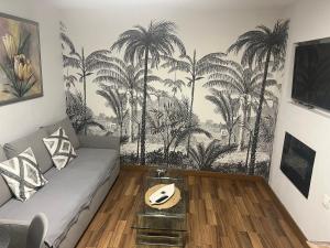 a living room with a couch and palm trees mural at Torres de la Catedral in Jaén
