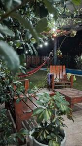 a wooden bench and a hammock in a garden at Quinta la hermosa in Villa María