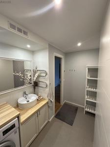 a bathroom with a sink and a washing machine at Koreli apartment in Võru +4 photos