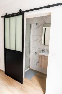 a black door in a bathroom with a sink at Au Cocon de J in Obernai