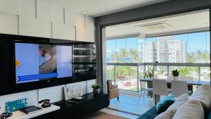 a living room with a couch and a tv at Pé na areia mod 5 Riviera de São Lourenço in Bertioga