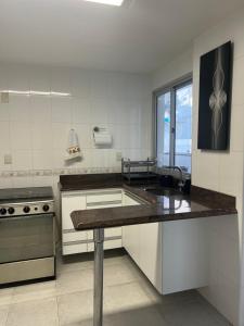 ガラパリにあるExcelente Apartamento na Praia das Virtudesのシンクとコンロのあるキッチン