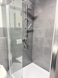 a shower with a glass door in a bathroom at Zentral gelegene Zimmer mit Gemeinschaftsküche und -bad in Herne