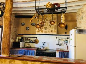 a kitchen with a refrigerator and some pots and pans at Casa Cueva ARACELI in Alcalá del Júcar