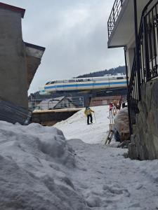 a group of people in the snow next to a train at Cabana Floare in Straja