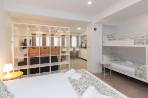 Un dormitorio con dos literas y una cocina. en BET Apartments - Abastos, en Valencia