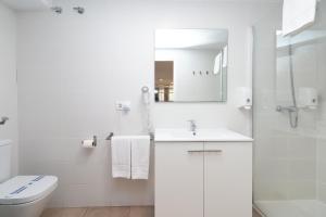Un baño blanco con inodoro y lavabo. en BET Apartments - Abastos, en Valencia 34 fotos más