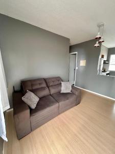 a living room with a brown couch in a room at Apartamento Cop 30 in Ananindeua +2 photos