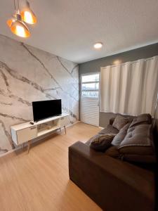 a living room with a couch and a flat screen tv at Apartamento Cop 30 in Ananindeua