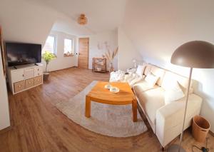 een woonkamer met een witte bank en een tafel bij Ferienwohnung Glücksquelle in Bad Pyrmont