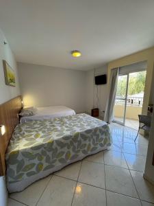 a bedroom with a bed and a sliding glass door at Condomínio Residencial Thermas Place Apto 119 in Caldas Novas