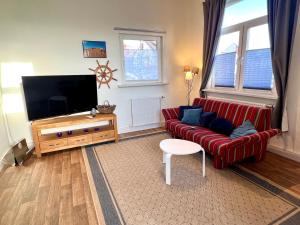 瓦尔斯罗德Tiny House im Stadtzentrum!的客厅里有一张红色沙发和一台平板电视