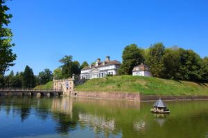 een huis op een heuvel met een boot op een rivier bij Ferienwohnung Glücksquelle in Bad Pyrmont