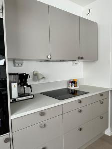 a kitchen with white cabinets and a counter top at Relaxing&Cozy doubleroom home in Jyväskylä +4 photos