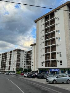 a parking lot with cars parked in front of tall buildings at Imperial Lux Apartment in Kragujevac