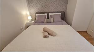a white bed with two rolled up towels on it at 4- Hypercentre, FREE Parking, Clim, Wifi, Netflix in Libourne
