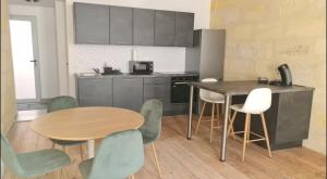 a kitchen with a table and chairs and a table and a counter at 4- Hypercentre, FREE Parking, Clim, Wifi, Netflix in Libourne