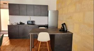 a kitchen with a counter and a refrigerator at 4- Hypercentre, FREE Parking, Clim, Wifi, Netflix in Libourne
