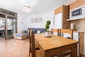 Una cocina y una sala de estar con una mesa y un sofá. en 2BR El Cotillo House - Private Terrace, en Cotillo