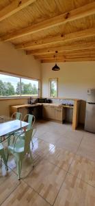 a large kitchen with wooden ceilings and a table and chairs at AltaVista Lago Ranco in La Unión
