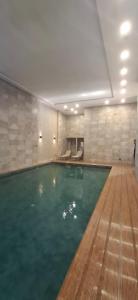 穆罕默迪耶Millénium vip parc appartement的大房间里有一个大游泳池，
