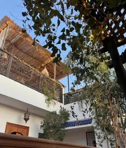 un bâtiment avec un auvent et un balcon orné de plantes dans l'établissement Riad Näjma privatisation, 2 Bassins, à Marrakech