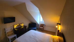 une chambre avec un lit, une télévision et une chaise dans l'établissement Charmant Duplex en bord de Dordogne - Argentat- Corrèze, à Argentat 22 autres photos