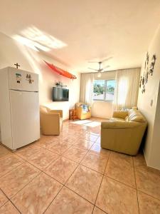 sala de estar con nevera y sofá en Apartamento 201, en Guaratuba