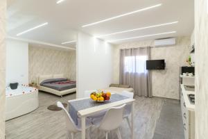 a living room with a table and chairs and a bedroom at Belsito Suite in Misterbianco