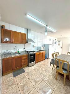 una cocina con armarios de madera y una mesa con mesa. en Apartamento 201, en Guaratuba