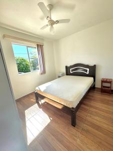 Un dormitorio con una cama con ventilador de techo. en Apartamento 201, en Guaratuba 3 fotos más