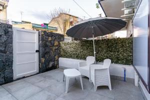 a table and chairs with an umbrella on a patio at Belsito Suite in Misterbianco