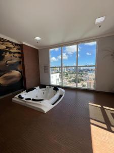 Un baño grande con bañera en una habitación con grandes ventanales. en iFlat Metropoliran Barcelona MB205B Jardim Goiás, en Goiânia 6 fotos más