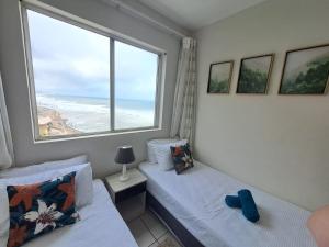 a bedroom with two beds and a large window at Ocean Tides - 2 Adults & 4 Kids ONLY in Umdloti +13 photos