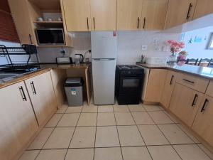 a kitchen with a white refrigerator and a stove at Ocean Tides - 2 Adults & 4 Kids ONLY in Umdloti