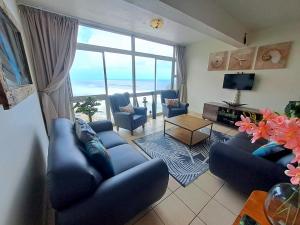 a living room with blue furniture and a large window at Ocean Tides - 2 Adults & 4 Kids ONLY in Umdloti
