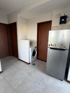 una cucina con frigorifero e lavatrice di CÉNTRICO DEPARTAMENTO con HERMOSA VISTA y amplios BALCONES a Santa Cruz de la Sierra