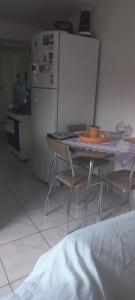 een keuken met een tafel met stoelen en een koelkast bij Espaço tranquilo in Florianópolis