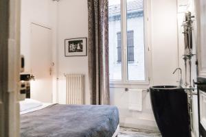 a bathroom with a bed and a sink and a window at Chanteclair in Cannes