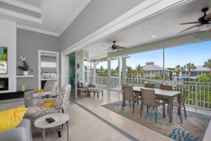 a living room with a table and chairs and a balcony at Memories on Madison by Sun Palace Vacations in Fort Myers Beach
