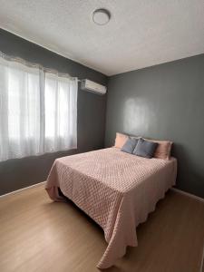 a bedroom with a bed with a pink blanket at Apartamento Cop 30 in Ananindeua