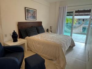 ein Schlafzimmer mit einem Bett, einem Sessel und einer Couch in der Unterkunft Casa à Beira-Mar em Itacimirim, Viva o Paraíso! in Camassari + 60 Fotos