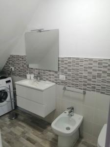łazienka z umywalką, toaletą i lustrem w obiekcie Sicilia Beddra w mieście Porto Empedocle