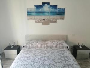 sypialnia z łóżkiem z 2 szafkami nocnymi i 3 obrazami w obiekcie Sicilia Beddra w mieście Porto Empedocle