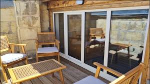 a screened porch with chairs and a table and chairs at 6- Hypercentre, 4pers, Climatisation ,Terrasse, Netflix in Libourne