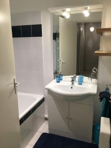 une salle de bain avec un lavabo, une baignoire et un miroir dans l'établissement Appart 3 pieces cosy avec parking proche centre ville, à Cahors