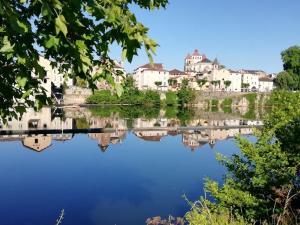 une ville réfléchissant dans l'eau dans l'établissement Appart 3 pieces cosy avec parking proche centre ville, à Cahors