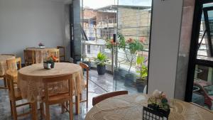 a restaurant with tables and chairs and a large window at Rivo Ohia Inn in Rioja