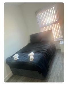 une chambre avec un lit avec deux serviettes dessus dans l'établissement Ashton Apartment, à Ashton-under-Lyne