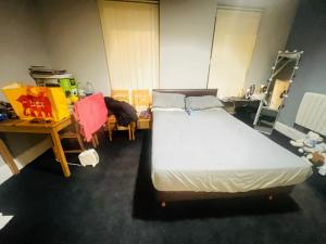 une chambre avec un grand lit et une table et des chaises dans l'établissement Ashton Apartment, à Ashton-under-Lyne